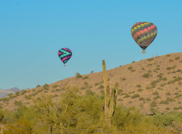 Békés repülés a napos Arizona felett egy élénk színű hőlégballonnal. Maricopa megye, Arizona - Fotó, kép