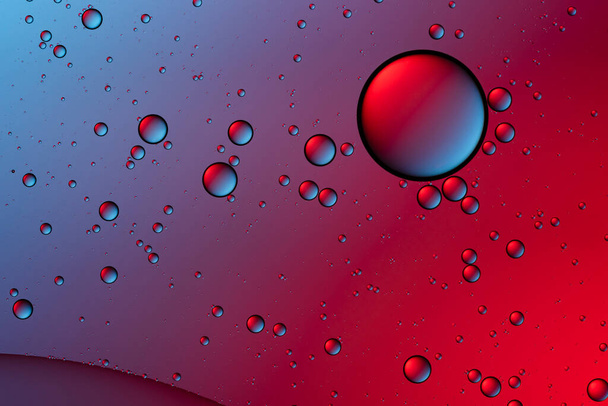 Kék és piros buborékok. Absztrakt háttér. Buborékolaj a vízen. Makrofotózás. - Fotó, kép