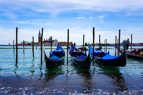 Venice on a beautiful day with small narrow canals and boats and gondolas floating under bridges in Venice, Italy. - Zdjęcie, obraz