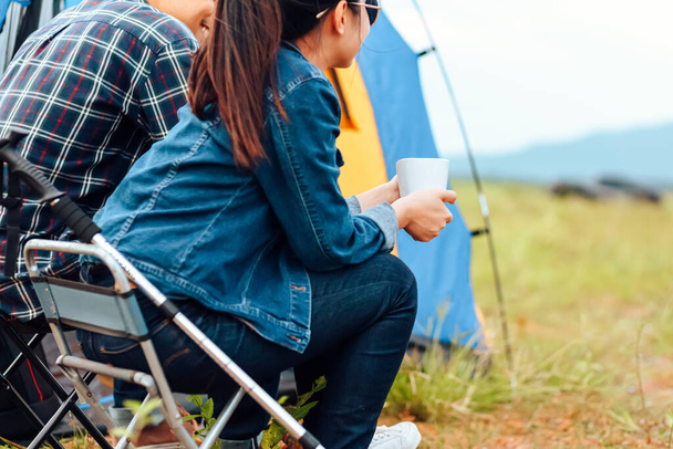 Couple drink coffee together at camping near the lake in the morning. - Fotoğraf, Görsel