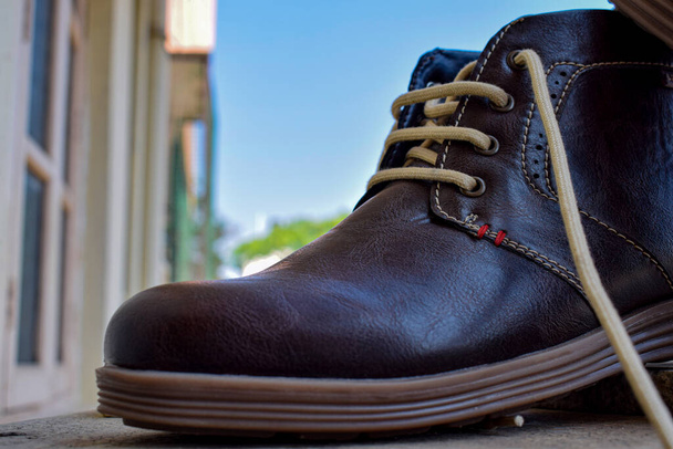 Vue latérale des chaussures classiques en cuir marron isolées sur fond flou - Photo, image