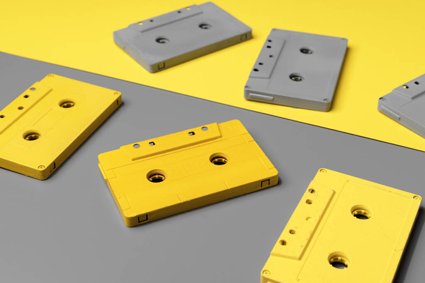 Audio cassettes on gray and yellow background top view - 写真・画像