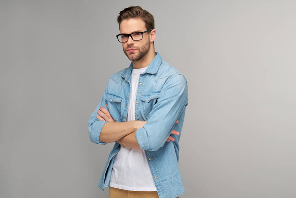 Portrait of young handsome caucasian man in jeans shirt over light background - Valokuva, kuva