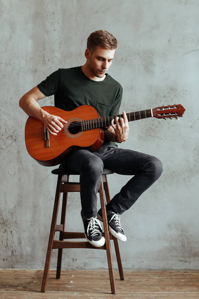 Pohledný muž s kytarou během jeho vystoupení - Fotografie, Obrázek