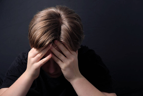 teenager sedí v uzavřeném postoji zažívá duševní zdravotní problémy, jako je deprese během COVID-19 uzamčení - Fotografie, Obrázek
