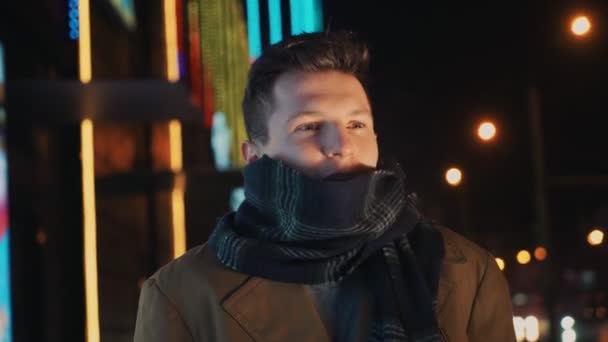 Homem congelando de pé frio perto da estrada e centro comercial à noite - Filmagem, Vídeo