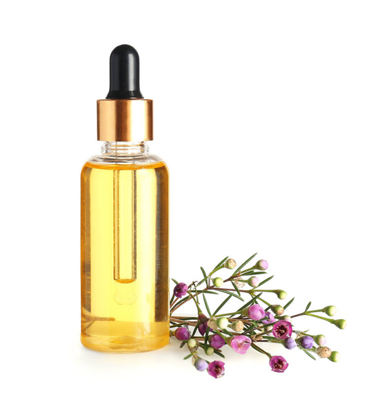 Botella con aceite esencial floral sobre fondo blanco - Foto, imagen