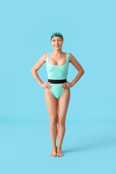 Female swimmer on color background - Foto, imagen
