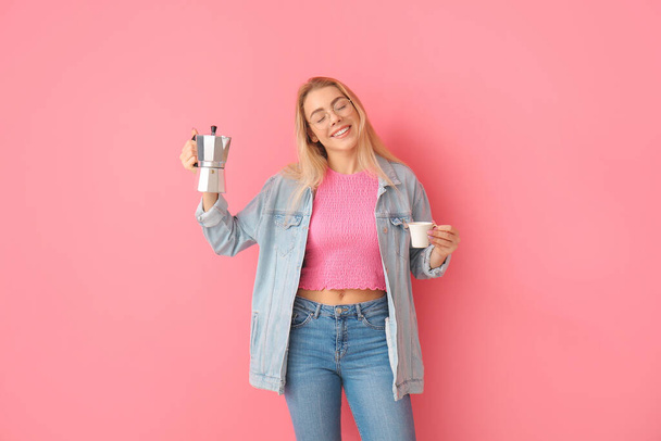 mooie jonge vrouw drinken hete koffie op kleur achtergrond - Foto, afbeelding
