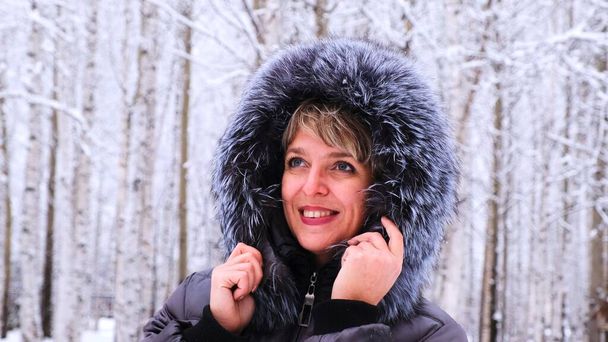 Zimní portrét mladé krásné brunetky v zimní bundě s kožešinou. Sněhová zimní krása koncept - Fotografie, Obrázek