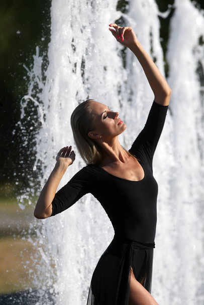 Eine junge, sehr schöne Frau posiert in einem Stadtbrunnen, Litauen, Kaunas - Foto, Bild