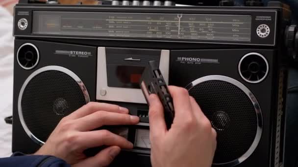 Mão masculina inserir fita cassete no gravador de áudio retro e pressiona o botão Play - Filmagem, Vídeo
