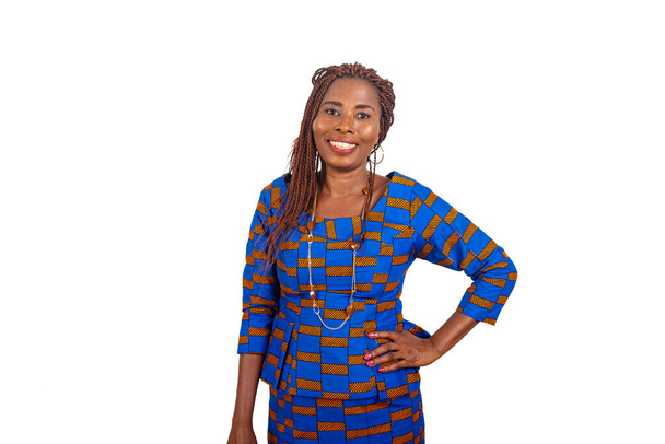 bela mulher de negócios Africano em vestido tradicional de pé no fundo branco mão no quadril sorrindo para olhar para a câmera - Foto, Imagem