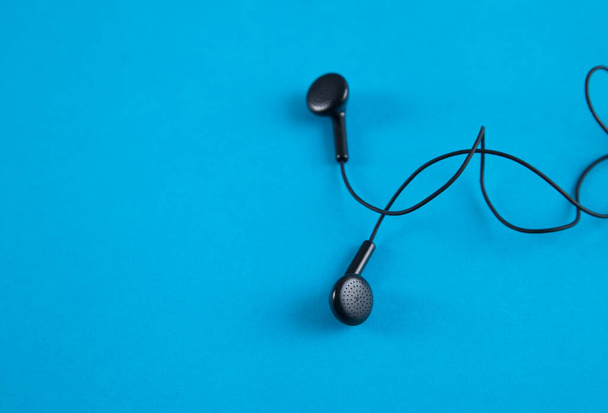 Schwarze Musik-Kopfhörer auf blauem Hintergrund. - Foto, Bild