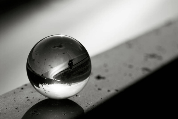Una vista de carretera a través de una bola de lentes. Bola de vidrio con vista invertida a la calle. Lente bola fotografía. - Foto, Imagen