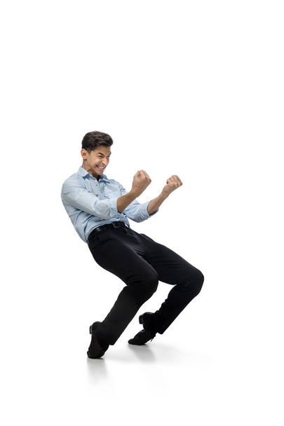 Happy young man dancing in casual clothes or suit, remaking legendary moves of celebrity from culture history - 写真・画像
