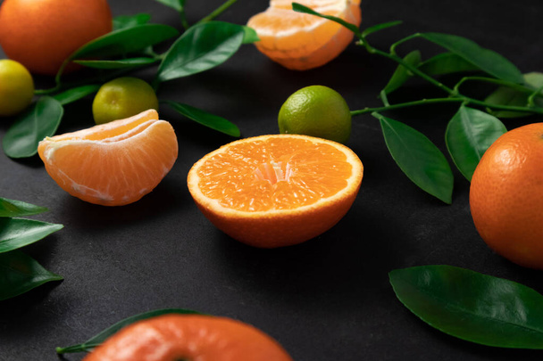 Mandarinas o clementinas con hojas sobre fondo negro. Vista superior con espacio de copia. - Foto, Imagen
