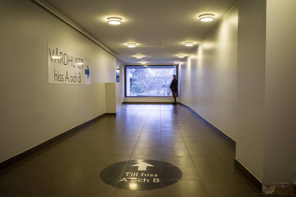 Estocolmo, Suecia Un hombre se encuentra en un largo pasillo en un centro de salud distirct. - Foto, imagen
