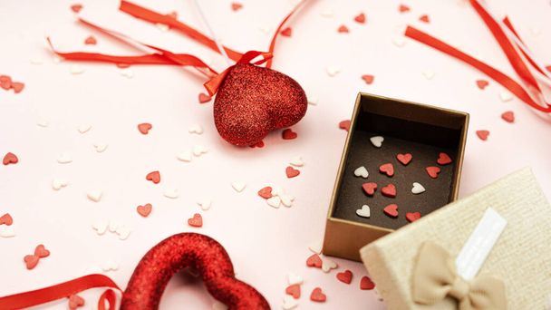 Küçük, tatlı, kırmızı ve beyaz şeker kalpler bir hediye kutusunda büyük kırmızı kalpler arasında çubukta - Fotoğraf, Görsel
