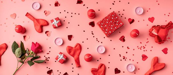 Ystävänpäivä. Punainen koristeet ilmapallot, kynttilät, konfetti ja lahjoja ylhäältä näkymä tasainen makasi vaaleanpunainen tausta - Valokuva, kuva