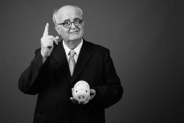 Estudio de tiro de hombre de negocios senior con sobrepeso con anteojos sobre fondo marrón - Foto, Imagen