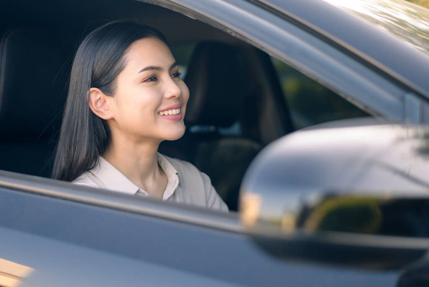 A beautiful young smiling woman driving her car, insurance and finance concept - Photo, image