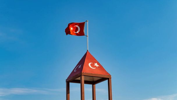 Turecka flaga machająca na błękitne niebo. Turcja kraj flaga płynąca na wietrze na błękitnym niebie. - Zdjęcie, obraz