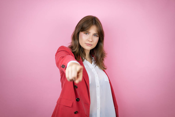 Jovem mulher de negócios sobre isolado fundo rosa apontando para a frente com o dedo - Foto, Imagem