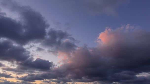 Hermoso cielo nocturno, pantalla completa. Sobre un fondo azul de color rosa y lila nubes cúmulos. Iluminación dorada. - Foto, imagen