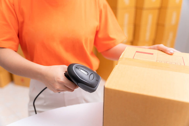 Close up hand of parcel delivery worker in warehouse with barcode scanner. - Photo, image