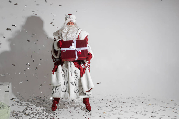Santa jumping with Christmas present. - Photo, Image
