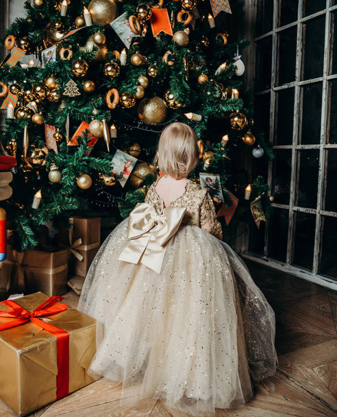 Toplar ve oyuncaklarla süslenmiş büyük bir Noel ağacı Noel hediyeleri ve kurdeleler. - Fotoğraf, Görsel
