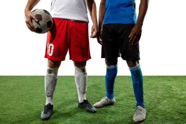 Крупный план ноги профессионального футбола, футболисты борются за мяч на поле изолированы на белом фоне - Фото, изображение