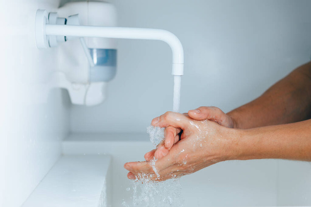 мытье рук под краном с текущей водой - Фото, изображение