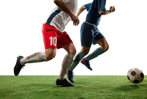 Close up legs of professional soccer, football players fighting for ball on field isolated on white background - Foto, imagen