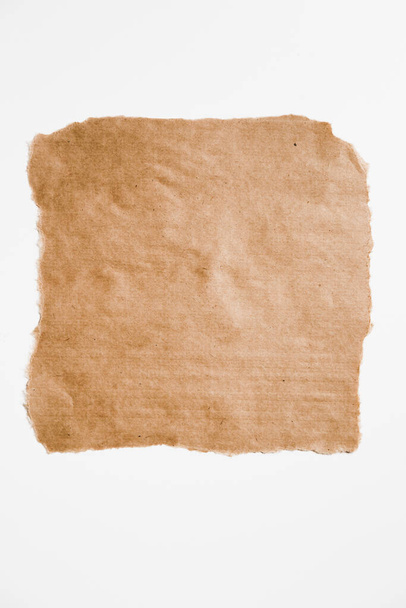 Quadrato strappato pezzo di carta marrone con bordi strappati isolato su bianco. - Foto, immagini