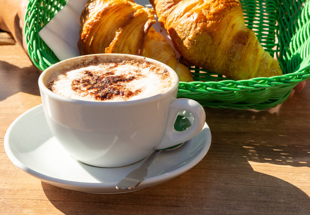 Französisches Frühstück in der Bäckerei serviert im Freien, Tassen Kaffee und frisch gebackene Croissants und Gebäck, Morgenessen aus nächster Nähe - Foto, Bild