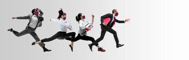 Happy office workers in face masks jumping and dancing in casual clothes or suit isolated on studio background. Creative collage. - Фото, зображення