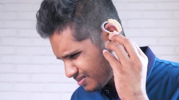 Ακουστική βοήθεια, ένας νεαρός άνδρας με προβλήματα ακοής. - Πλάνα, βίντεο