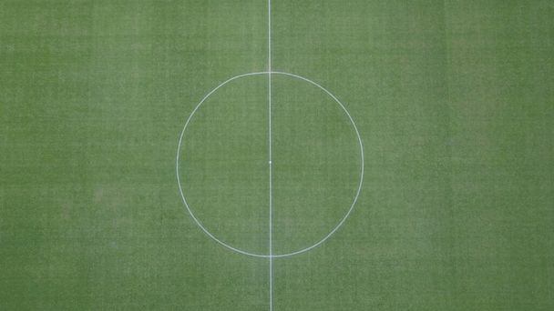 Вид з повітря на центр футбольного поля. Центральна лінія на траві футбольного та футбольного поля
. - Фото, зображення