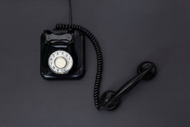 Vue du dessus du téléphone rétro des années 1960 isolé sur fond noir. Espace pour le texte. Concept de communication. - Photo, image