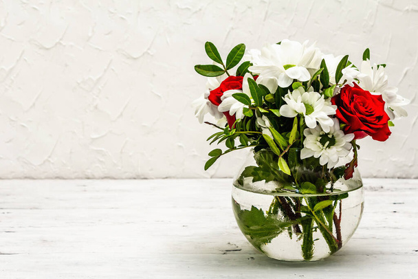 A bouquet of fresh flowers in glass vase. Valentine's day or Wedding concept. White old planks background - Photo, Image