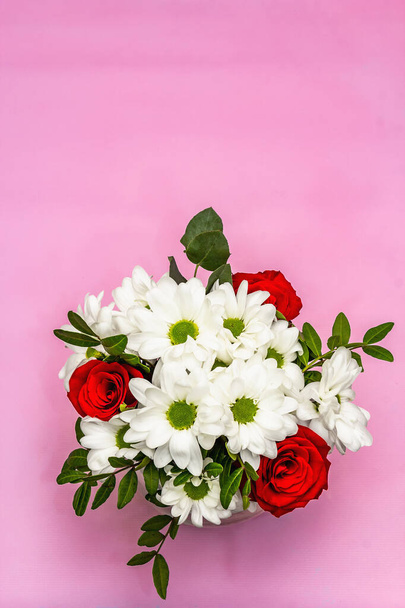 Ένα μπουκέτο από φρέσκα λουλούδια σε γυάλινο βάζο. Ημέρα του Αγίου Βαλεντίνου ή έννοια του γάμου. Απαλό ροζ ανάγλυφο φόντο - Φωτογραφία, εικόνα