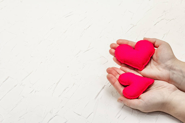 Conceito do Dia dos Namorados. As mãos femininas seguram corações de feltro caseiros. branco putty texturizado fundo - Foto, Imagem