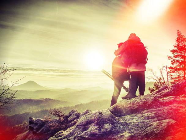 Sylwetka kobiety i mężczyzny fotograf trzymać statyw na zachód słońca szczyt. Filtr abstrakcyjny. - Zdjęcie, obraz