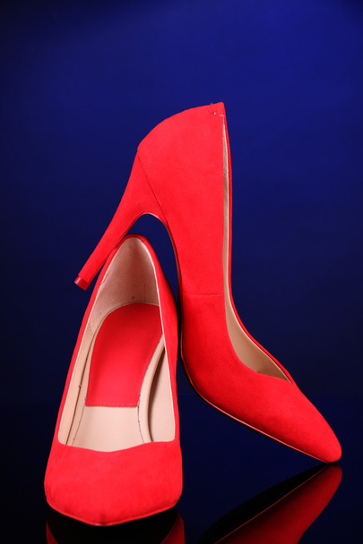 Beautiful red female shoes, on blue background - Foto, Imagem