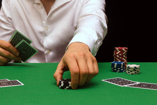 Homme en chemise blanche joue au poker dans une entreprise de jeu dans un casino. Industrie des boîtes de nuit. Beaucoup d'argent. Le poker en ligne. espace de copie - Photo, image