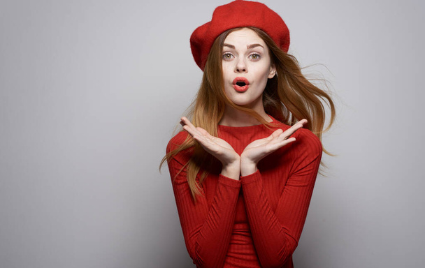 mooie vrouw in rode jurk glamour hoed emoties verrast blik - Foto, afbeelding