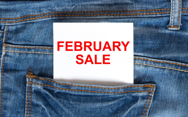 Text February Sale on white paper in the pocket of blue denim jeans. Can be use as marketing concept - Φωτογραφία, εικόνα