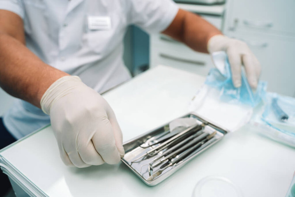 Doctors assistant opens a silver dental instrument tray - Foto, afbeelding